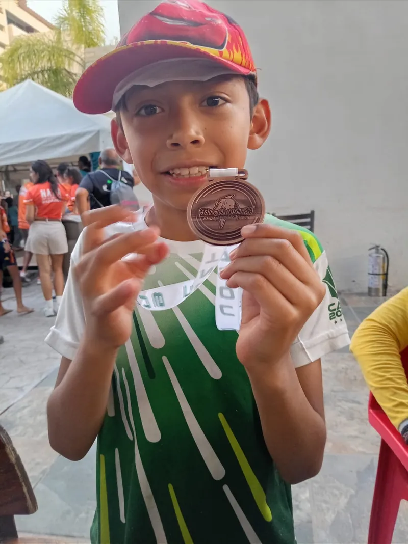 Adrián mostrando una medalla deportiva